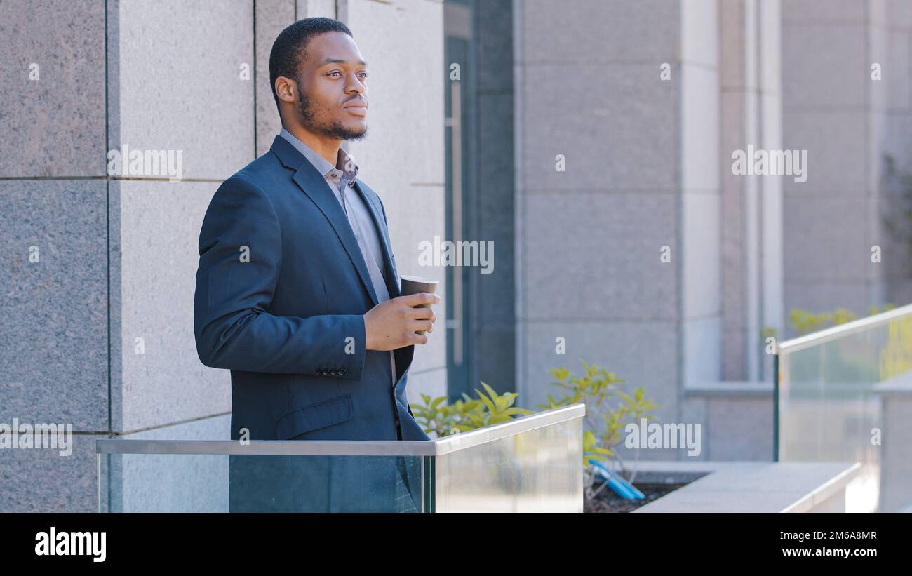 Afroamerikanischer Geschäftsmann pensive entspannte, nachdenkliche Unternehmer Büroangestellter Manager männlicher Arbeitgeber, der auf dem Balkon steht und nachdenkt Stockfoto