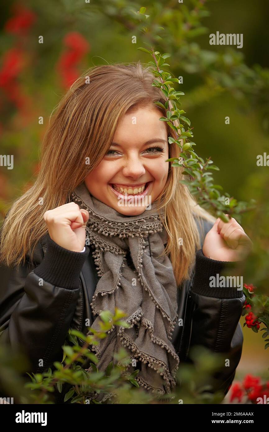 Wunderschönes positives Mädchen im Gebüsch Viburnum Stockfoto