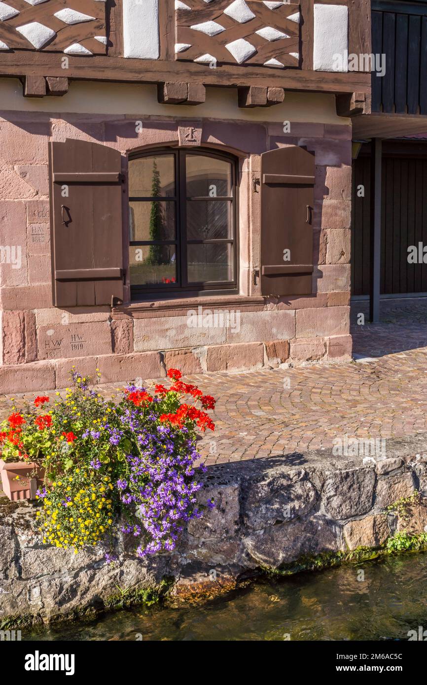 Ein Fachwerkhaus am Ufer eines Bachs, schi Stockfoto