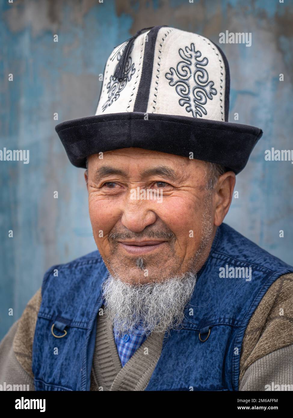 Murghab, Gorno-Badakshan, Tadschikistan - 08 27 2019 : Nahporträt eines alten Mannes mit traditionellem kirgisischem Kalpak-Hut auf dem Markt entlang der Pamir-Autobahn Stockfoto