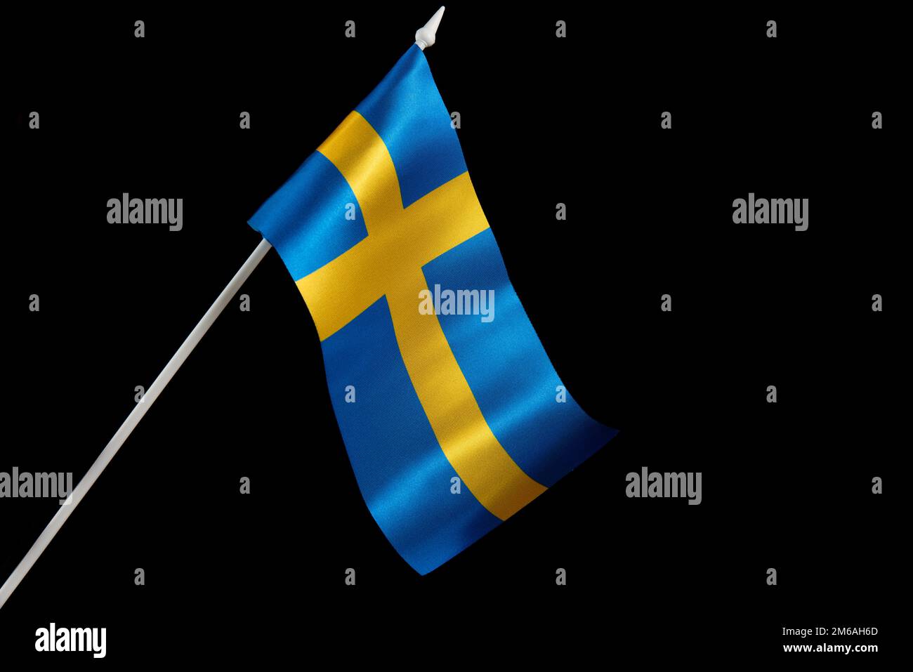 Die schwedische Flagge winkt. Die schwedische Flagge auf schwarzem Hintergrund entwickelt sich und fliegt im Wind. Stockfoto