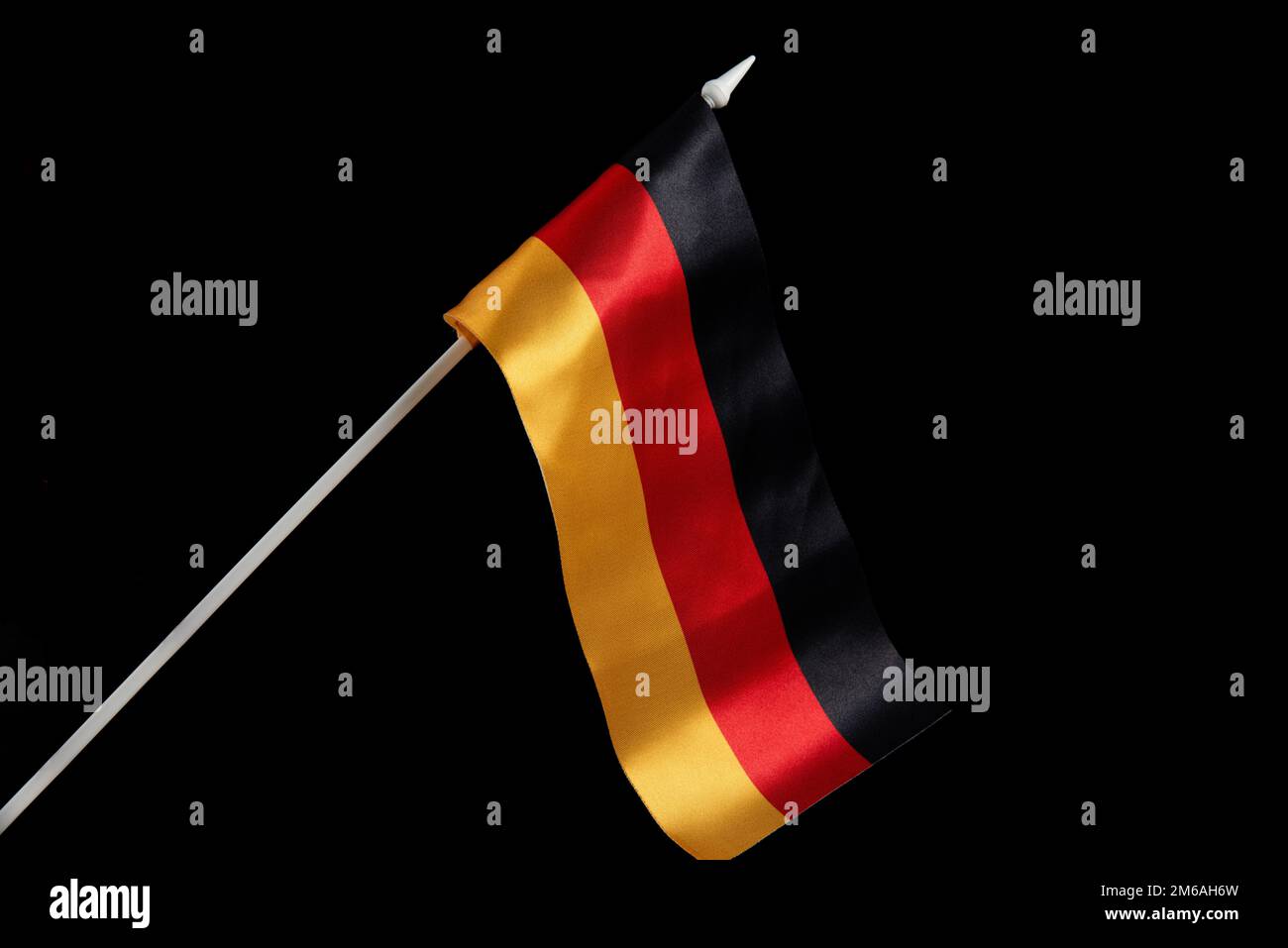 Die deutsche Flagge auf schwarzem Hintergrund entwickelt sich und fliegt im Wind Stockfoto