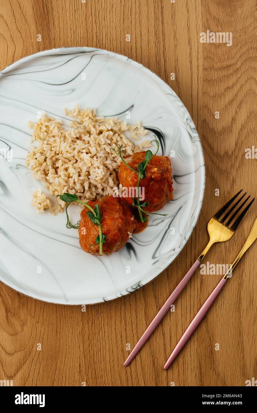 Gekochter Reis mit Fleischbällchen in Tomatensoße Stockfoto
