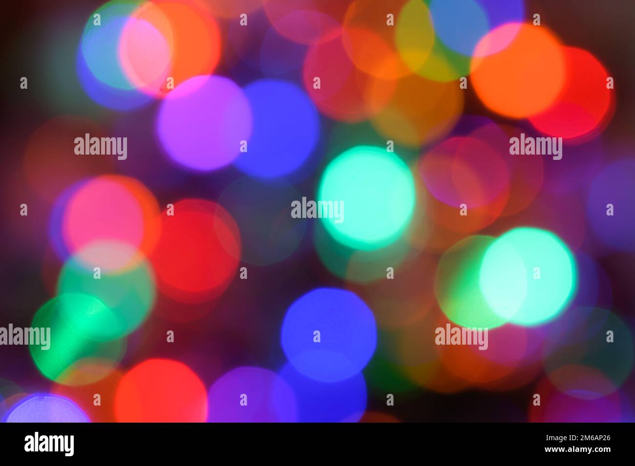Bunte, verschwommene Lichter, die sich im Hintergrundmuster mit Bokeh-Lichtpunkten überlappen Stockfoto