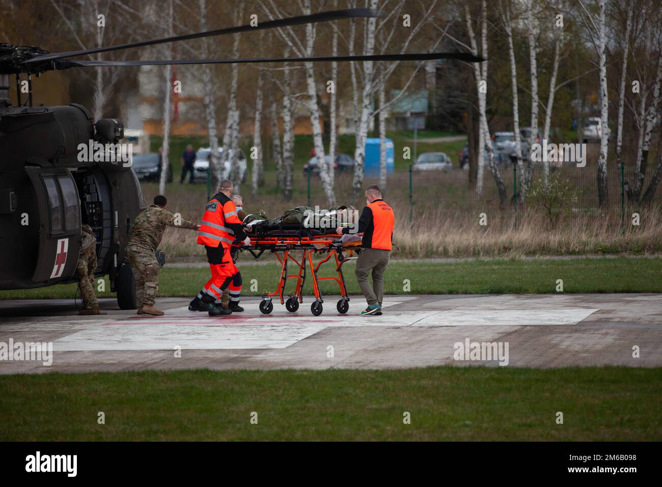 Ein Patient wird aus einem Helikopter der US Army H-60 Black Hawk verlegt, der von CO/2-227 AVN REGT, von poliertem medizinischem Personal des Konin-Krankenhauses betrieben wird. Stockfoto