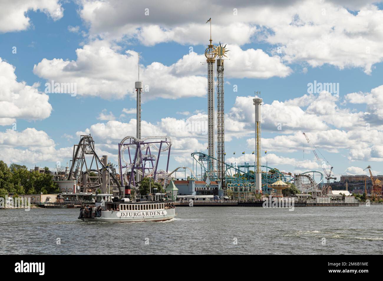 Fähre im Hafen und Fahrten im Vergnügungspark Tivoli Groena Lund auf der Halbinsel Djurgarden, Stockholm, Schweden Stockfoto