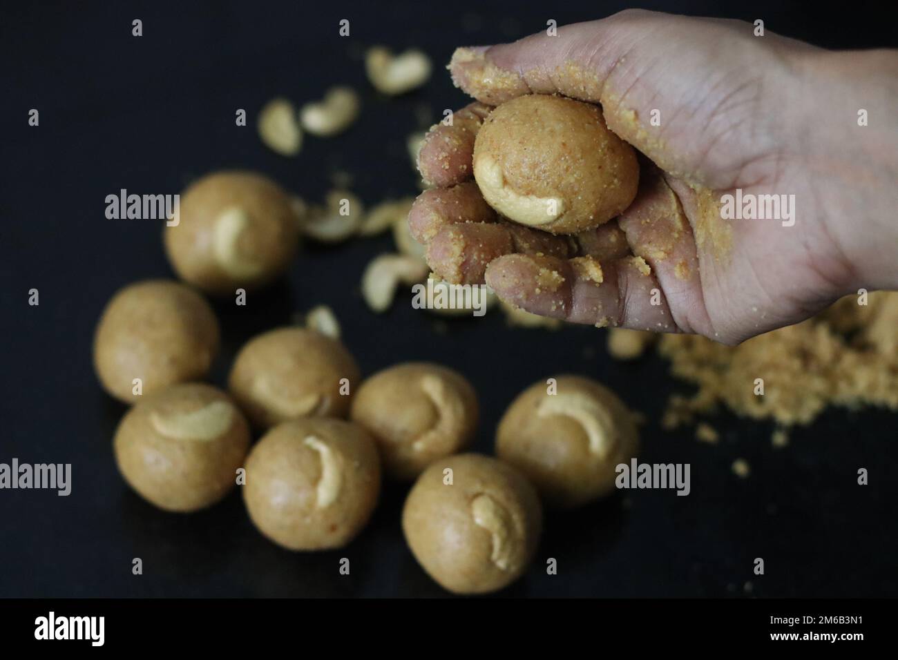 Herstellung von Moong dal laddu in Kugelform mit der Hand. Es ist eine ...