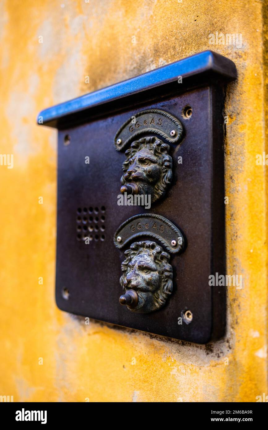 Nahaufnahme einer venedig Türklingel in Form eines Löwenmauls an einer orangefarbenen Wand im Winter 2022 Stockfoto