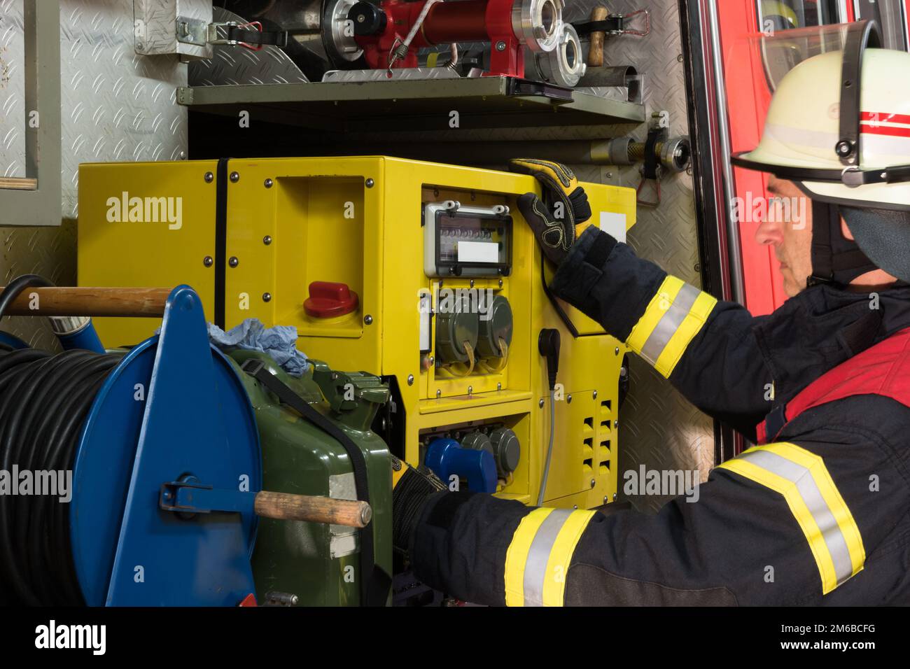 Feuerwehrmann in Aktion am Stromerzeuger Stockfoto