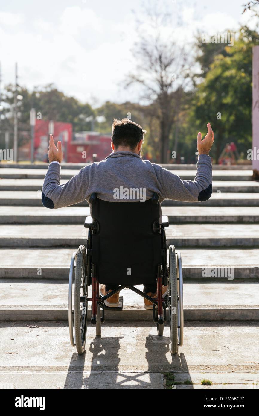 Ein Mann im Rollstuhl war frustriert und enttäuscht, dass er die Treppe nicht hochgehen konnte. Stockfoto