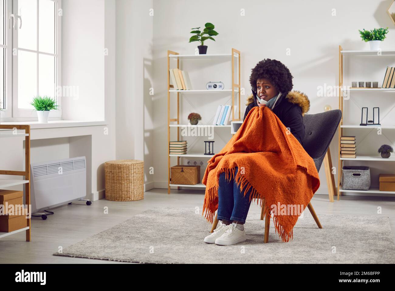 Junge afroamerikanische Frau friert im Haus während eines sehr kalten Winters Stockfoto