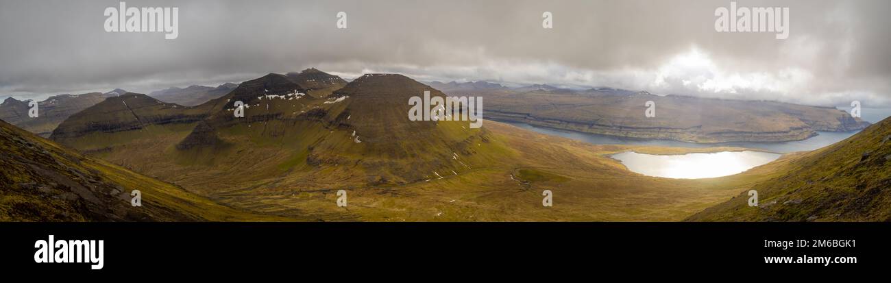 Wandern mit Blick auf Vaðhorn, Blámansfjall und Slættaratindur Húsafjall mit See EIDI, Sundini Sound und Streymoy Island im Hintergrund Stockfoto