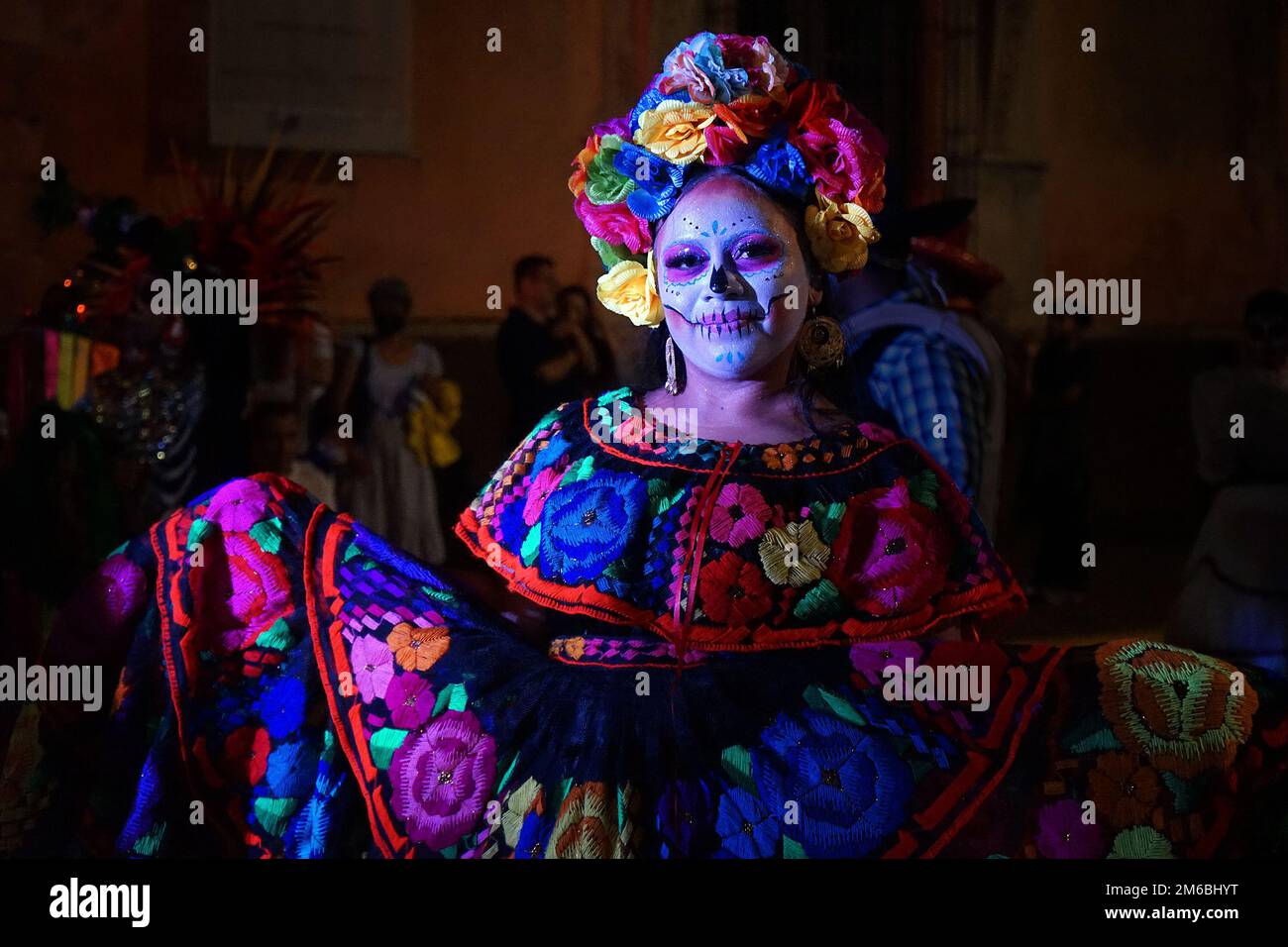 Eine Frau, die traditionell gesticktes mexikanisches Folk-Kleid und geblümten Kopfschmuck für die Catrina Parade, Teil von Day of the Dead, Merida, Mexiko trägt Stockfoto