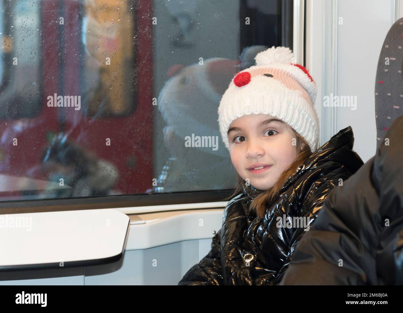 Ein Mädchen in einem Zugwaggon während der Weihnachtsferien Stockfoto