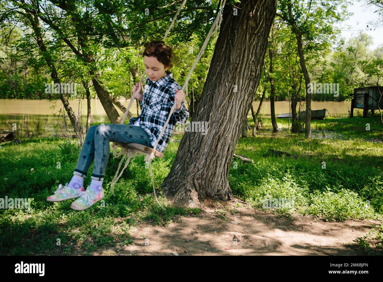 Ein Mädchen, das auf einer Seilschaukel reitet Stockfoto