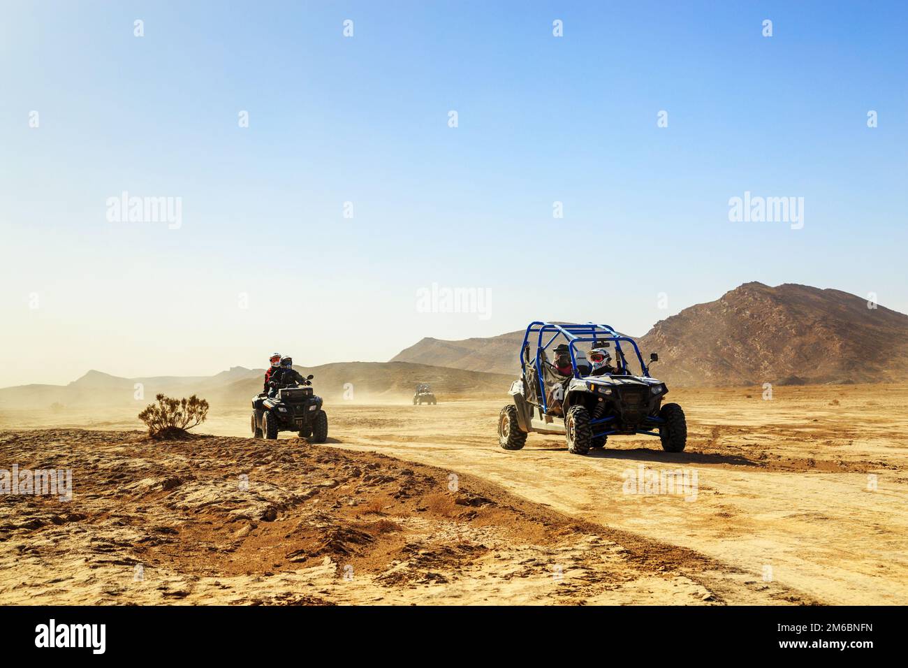 Merzouga, Marokko - 24. Februar 2016: Konvoi von Geländefahrzeugen (RZR, Quad und Motorräder) in der marokkanischen Wüste bei Merzouga. Merzou Stockfoto
