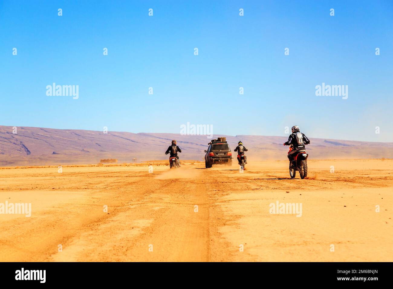 Merzouga, Marokko - Februar 22 2016: Konvoi von Geländefahrzeugen (4x4 und Motorräder) in der marokkanischen Wüste bei Merzouga. Merzouga ist f Stockfoto