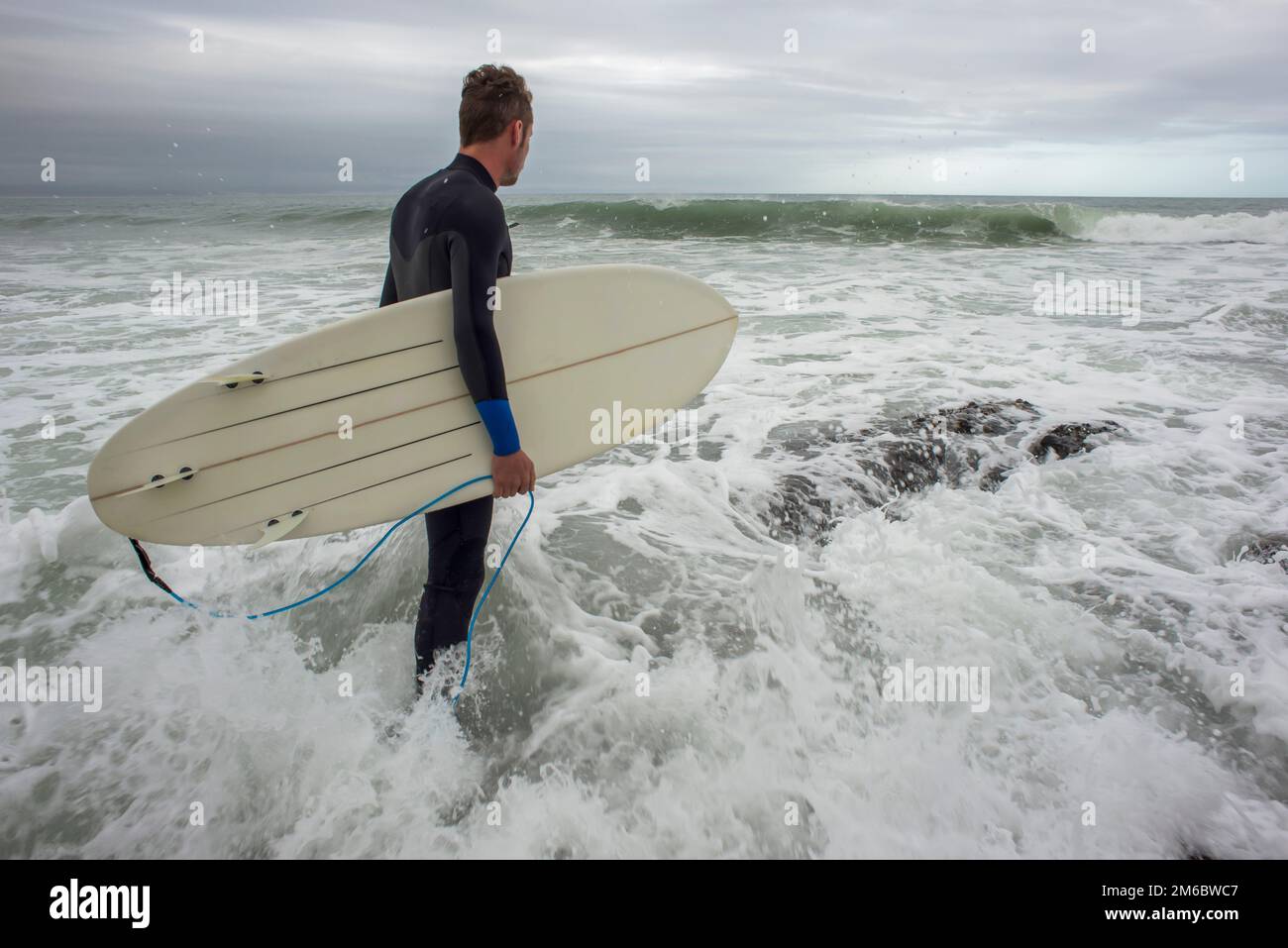 Surfer betritt den Ozean Stockfoto