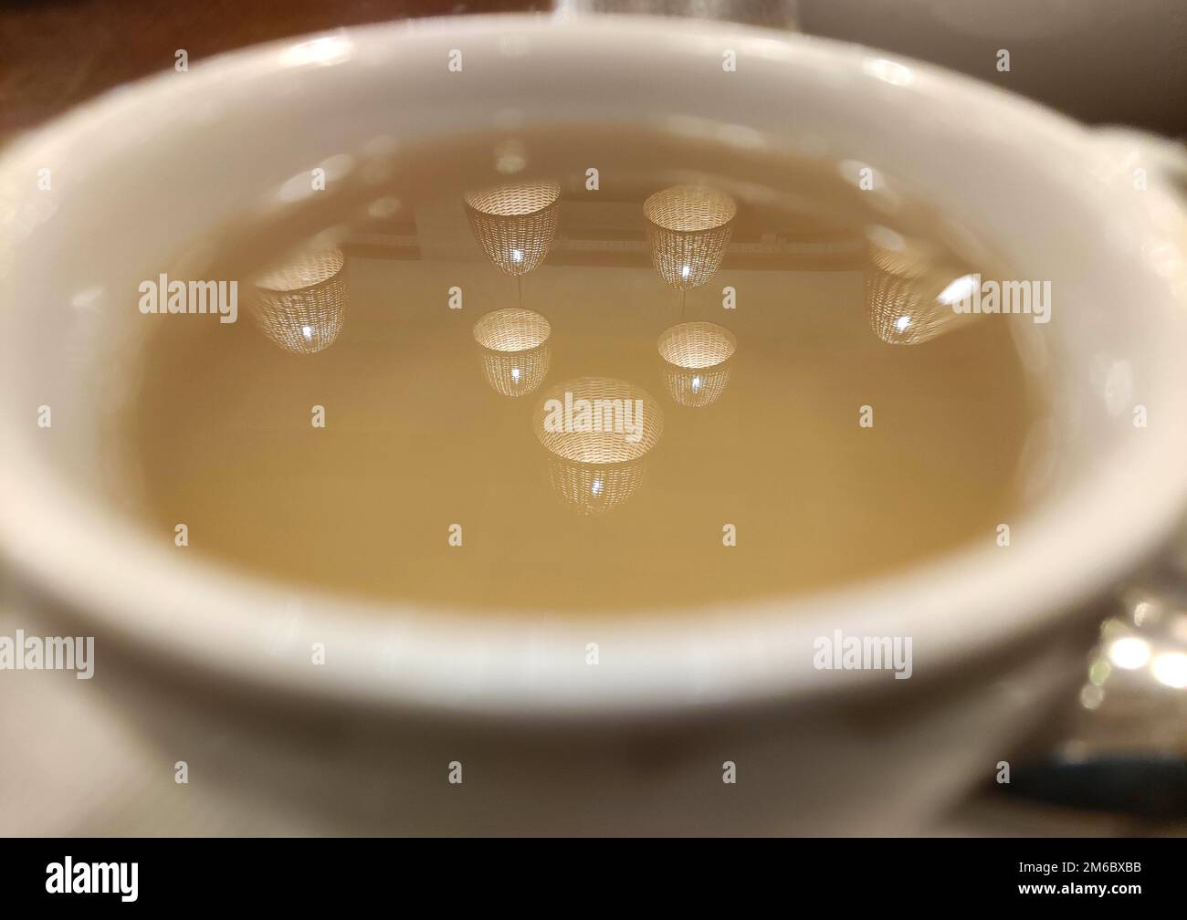 Lichtreflexion in einer Tasse Tee-Hintergrund, abstrakte Tapete Stockfoto