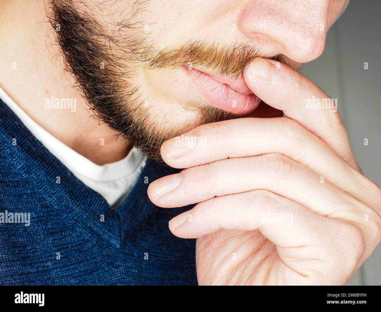 Männliche Person, bei closeup mit den Fingern im Bart Stockfoto