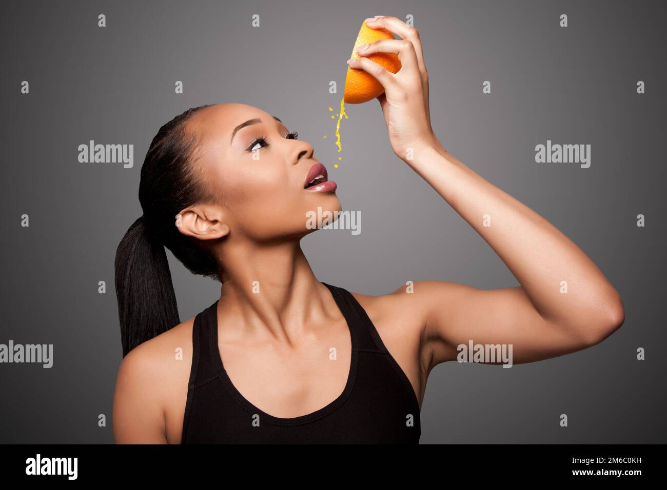 Glücklich gesund Schwarz asiatische Frau quetschen Orangensaft Frucht Stockfoto