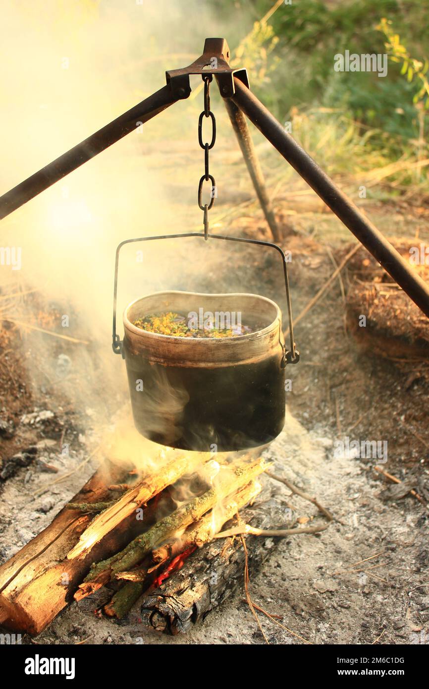 Kochen Essen im Bowler am Feuer. Sommerzeit Stockfoto