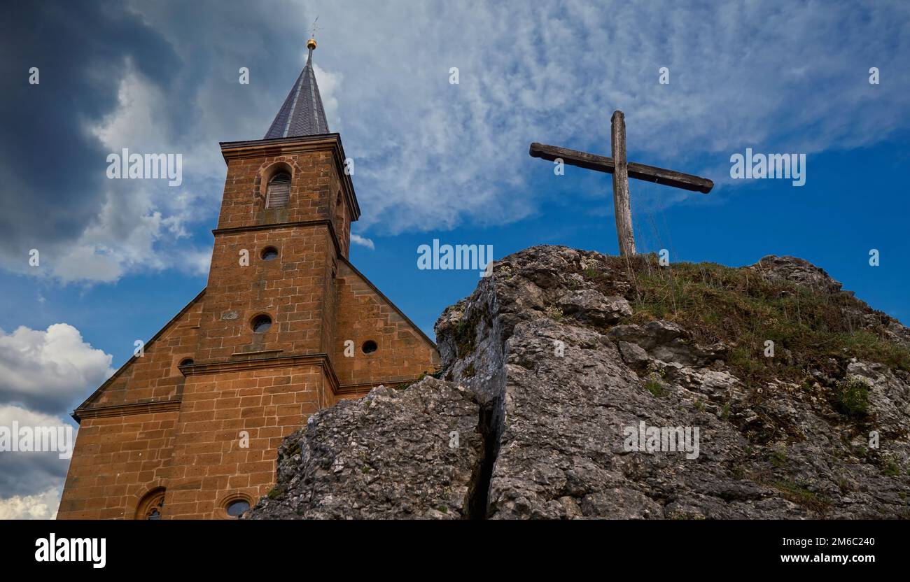 Sehen Sie sich auf eine Kirche und ein Kreuz vor einem wunderbaren bewölktem Himmel Stockfoto