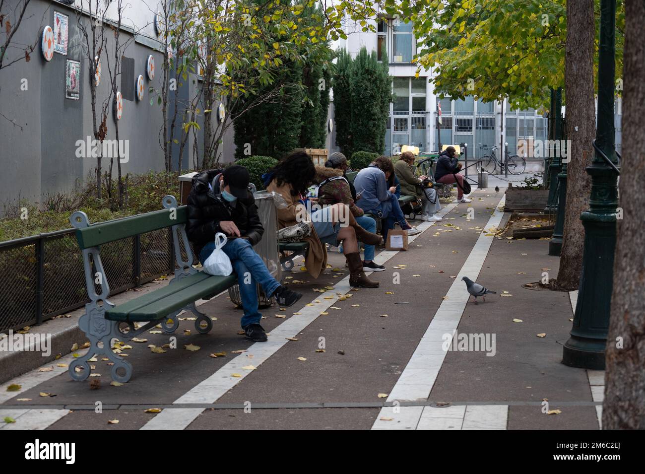 Leute sitzen auf einer Bank vor der Passage du Grand Cerf, Paris, 2022. Stockfoto
