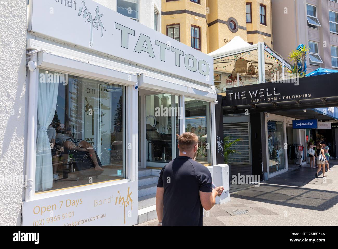 Bondi Beach Ink Tattoo Shop mit Leuten, die Tätowierungen auf ihren Körper angebracht haben, Bondi, Sydney, NSW, Australien Stockfoto