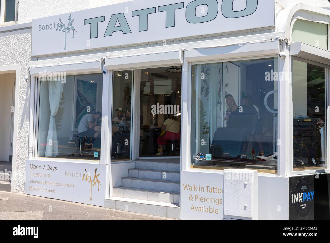 Bondi Beach Ink Tattoo Shop mit Leuten, die Tätowierungen auf ihren Körper angebracht haben, Bondi, Sydney, NSW, Australien Stockfoto