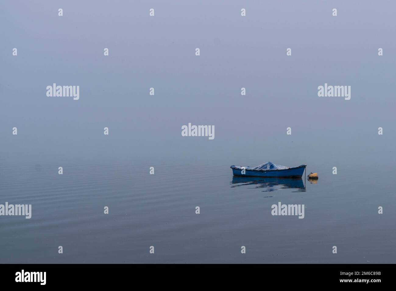 Boot auf Ruhe spät Wasser in einer nebligen Morgen Stockfoto