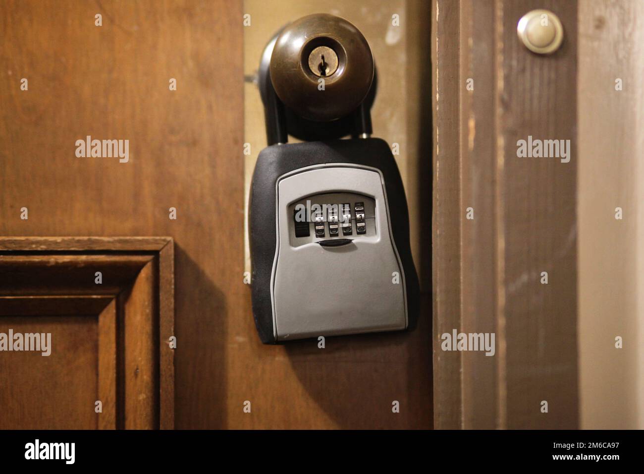 Kombi-Schlüsselschloss-Box hängt an altem Holztürgriff Stockfoto