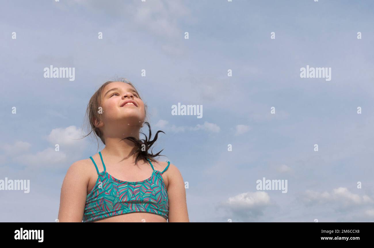 Mädchen auf dem Meer vor blauem Himmel und Wolken Stockfoto