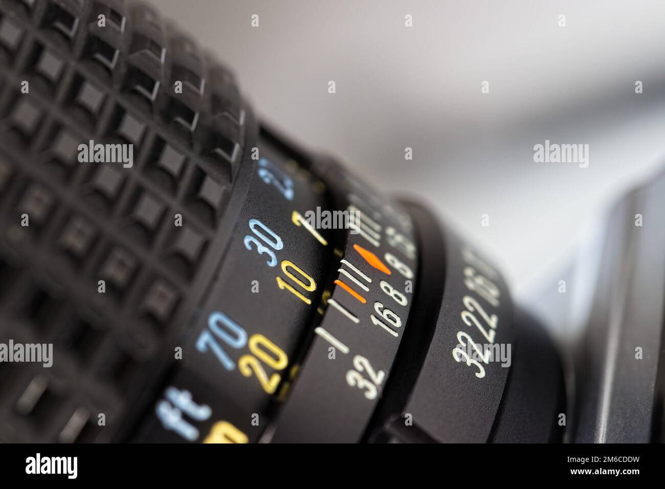 Nahaufnahme eines schwarzen Objektivs mit klaren, scharfen Linien sowie gelben, blauen und weißen Zahlen. Aufnahme in einem Aufwärtswinkel, geringe Schärfentiefe. Stockfoto