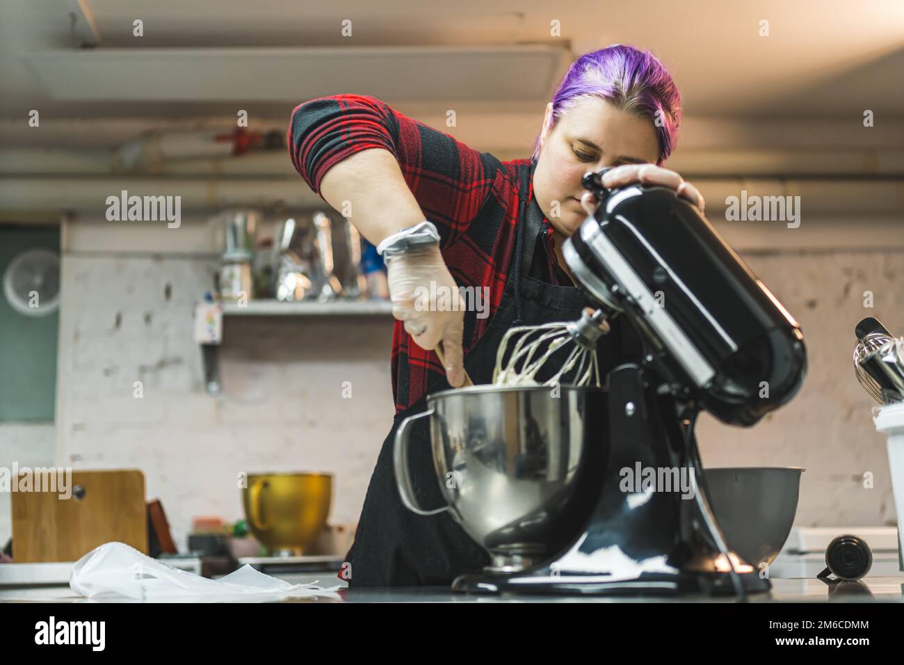 Eine Person, die Kekse backt. Professioneller Teigkoch, der den Teig aus der Küchenmaschine herausnimmt. Kopierraum im Innenbereich. Hochwertiges Foto Stockfoto