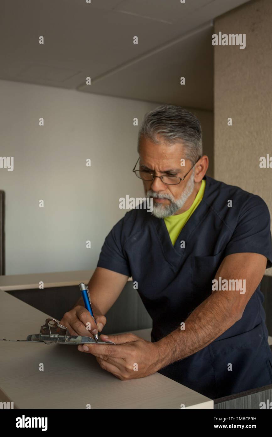 Attraktiver Oberarzt in dunkelblauer medizinischer Uniform Stockfoto