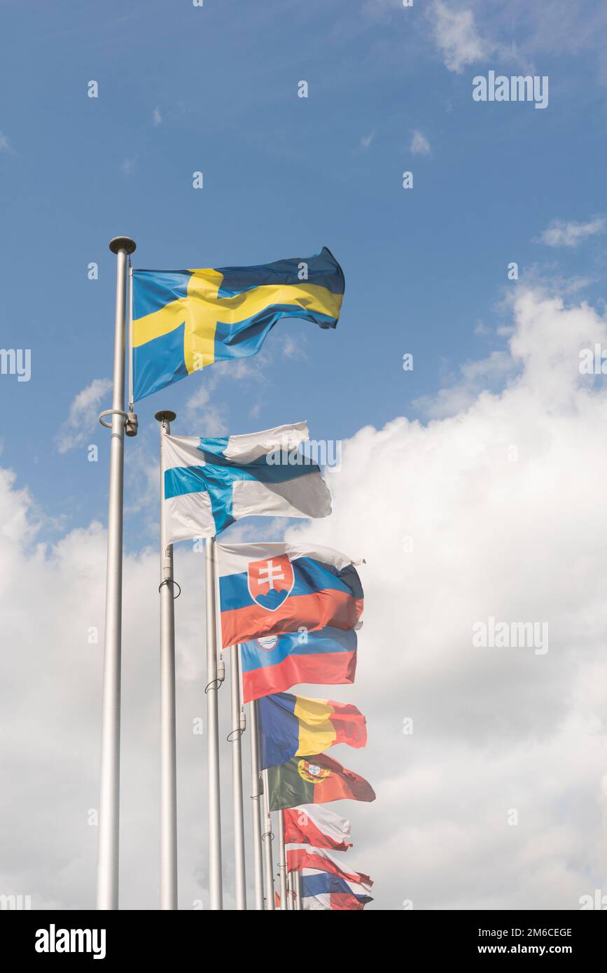 Eine Reihe von Flaggen der Europäischen Union vor blauem Himmel und Wolken Stockfoto