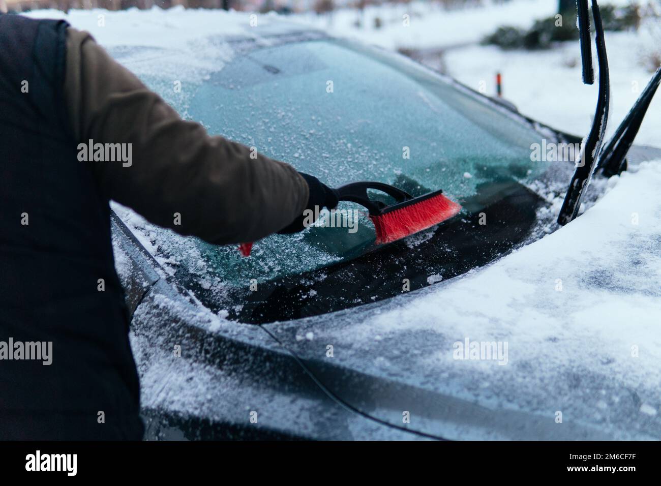 Premium Photo  Eine mannerhand kehrt mit einem besen den schnee vom weien  auto