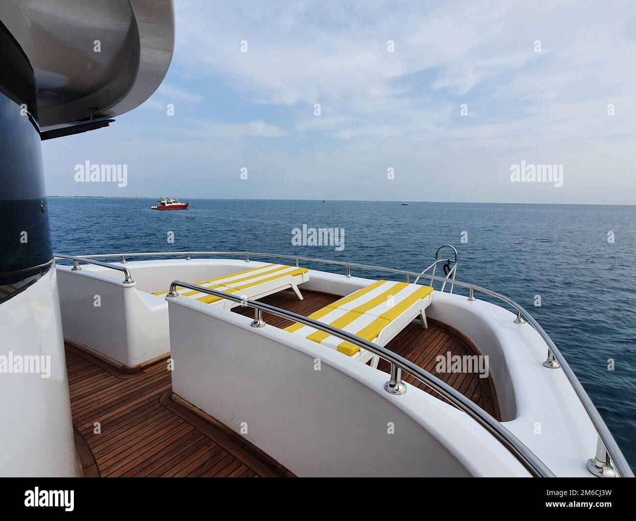 Kreuzfahrtschiff elegante Sonnenliege mit gelber Streifenband auf dem Bootsdeck mit Blick auf die Landschaft auf dem Mittelmeer, Europa Sommerurlaub. Stockfoto