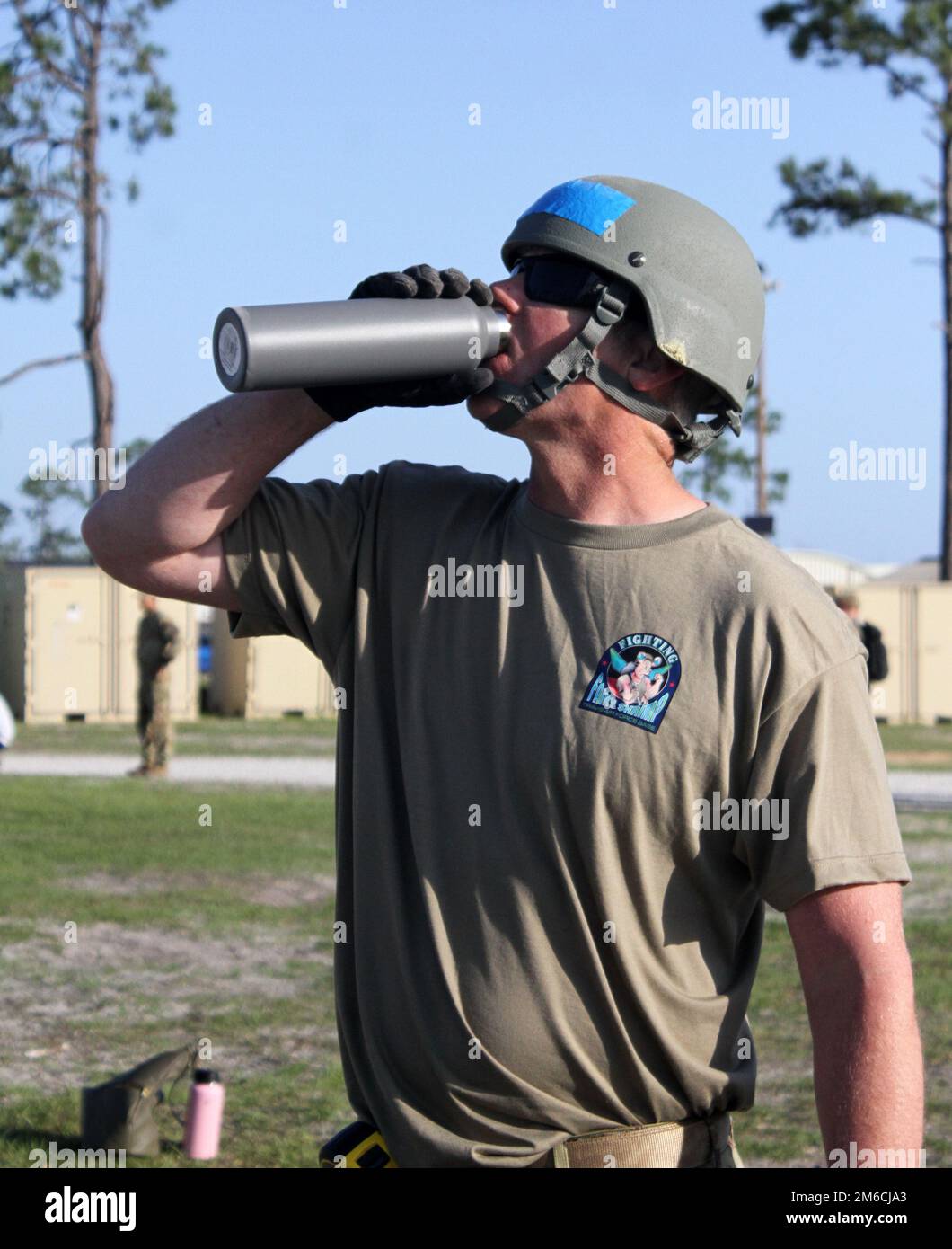 Ein Teilnehmer an der Readiness Challenge VIII des 60. Civil Engineer Squadron des Air Mobility Command, Luftwaffenstützpunkt Travis, Kalifornien, schnappt sich Wasser, während er das kleine Schutzsystem anpackt, das am letzten Morgen des Wettbewerbs am 22. April 2022 auf dem Silver Flag Übungsgelände, Luftwaffenstützpunkt Tyndall, Florida, errichtet wurde. Die Veranstaltung der Abteilung der Luftwaffe CE wird vom Air Force Civil Engineer Center ausgerichtet. Nach mehr als 20 Jahren Pause ist die Challenge, eine der wichtigsten Veranstaltungen für DAF-Bauingenieure, wieder da. Die diesjährige Readiness Challenge ist das erste Event zur Betriebsfähigkeit, bevor die Herausforderung den Fu erreicht Stockfoto