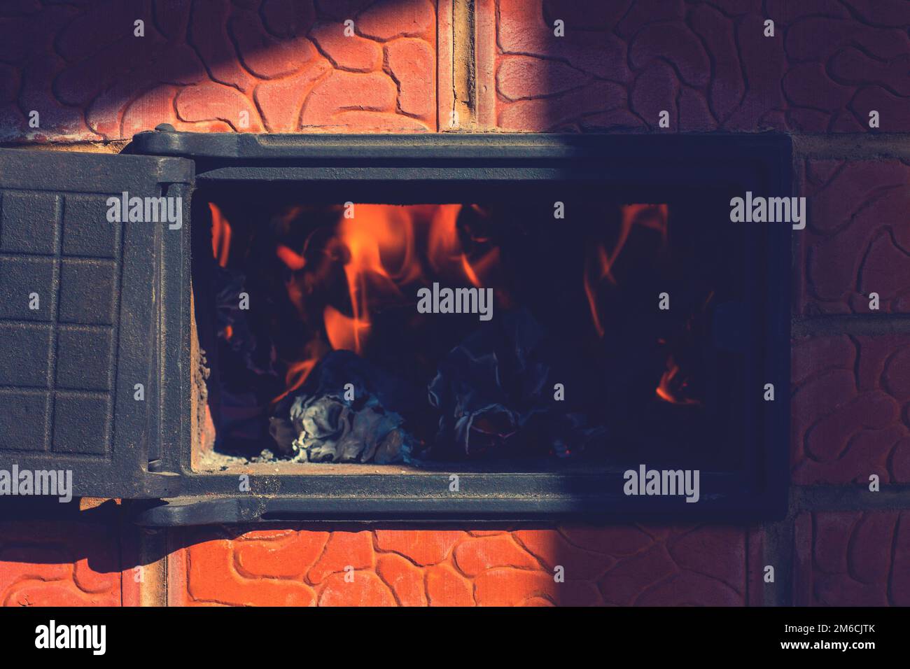 Feuer im Ofen bei offener Tür. Stockfoto