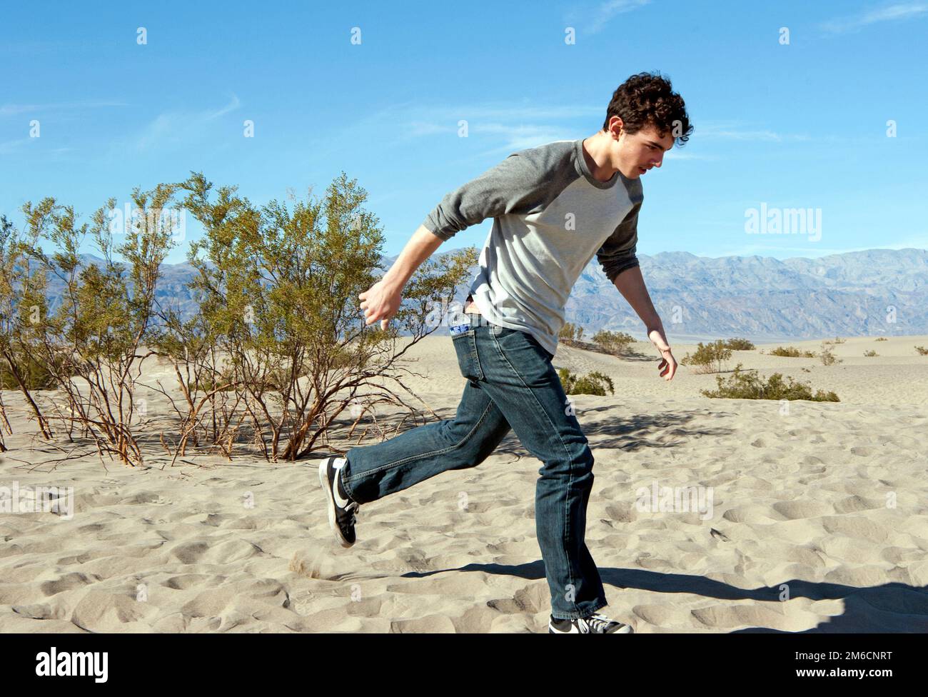 Ein Junge rennt in den Sanddünen im Death Valley-Nationalpark, Kalifornien, USA Stockfoto