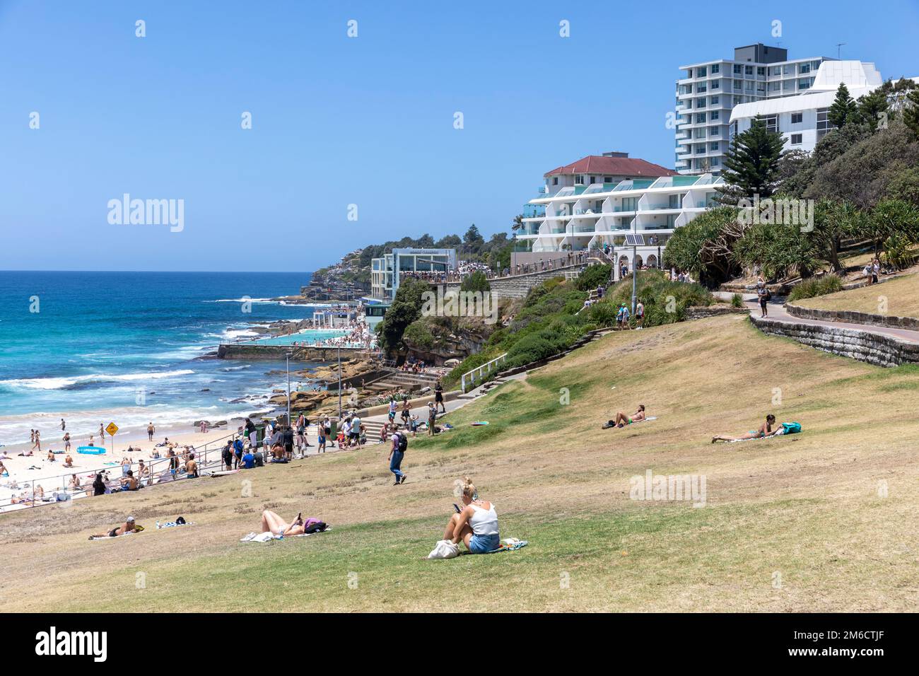 Bondi Strand und Park, Blick Richtung Süden bondi und Bondi Eisberge, Leute sonnen im Sommer 2023, NSW, Australien Stockfoto