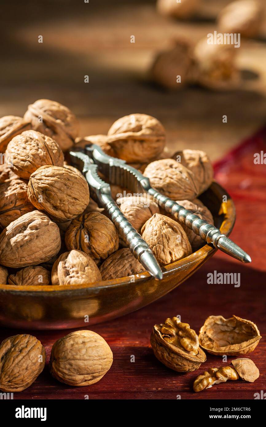 Stillleben mit Walnüssen in einer Holzschüssel auf einem Tisch Stockfoto