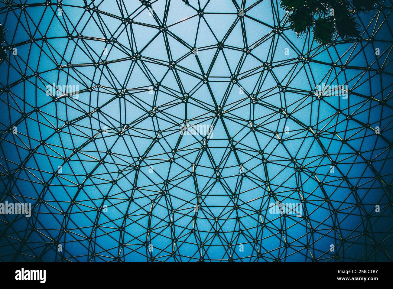 Gewölbte Decke aus gewölbter Stahlkonstruktion mit blauem Himmelshintergrund. Stockfoto