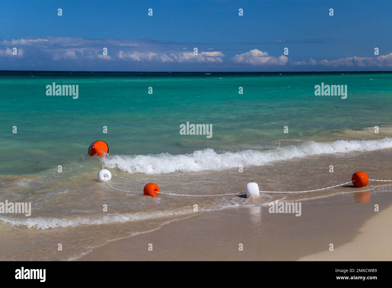 Schwimmerleine auf einer weichen Welle in einem weißen Sandstrand Stockfoto