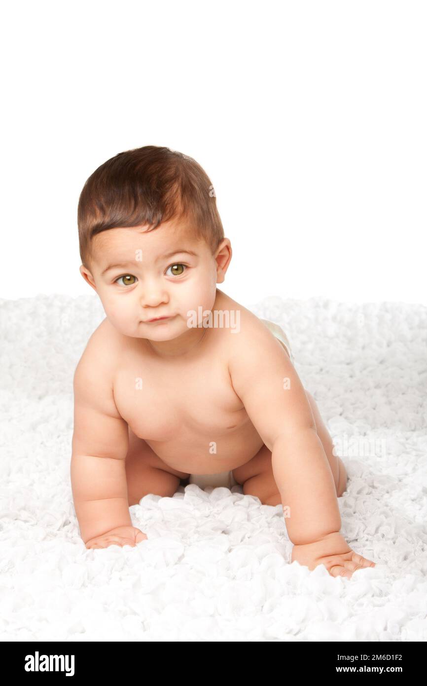 Süßes Baby mit großen grünen Augen, die auf Weiß krabbeln Stockfoto