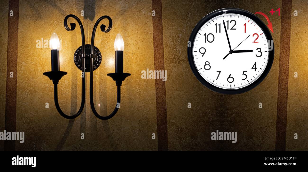 Sommerzeit. DST. Wanduhr geht auf Winterzeit. Dreh die Zeit vorwärts. Stockfoto