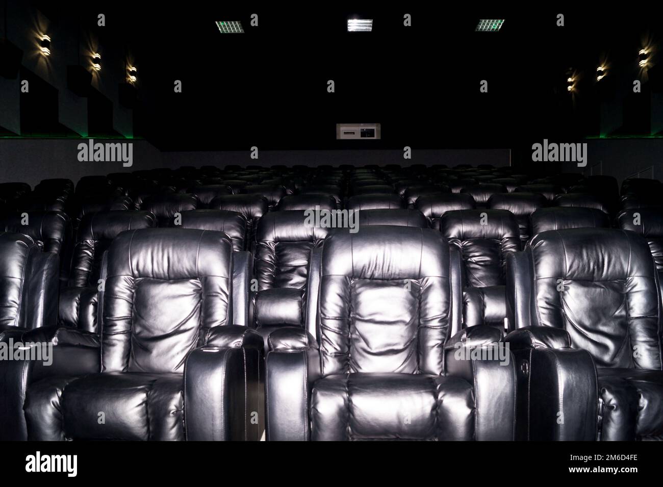 Das Innere eines Kinosaals mit schwarzen Ledersitzen. Der Film wird nicht gezeigt und es gibt keine Menschen. Stockfoto