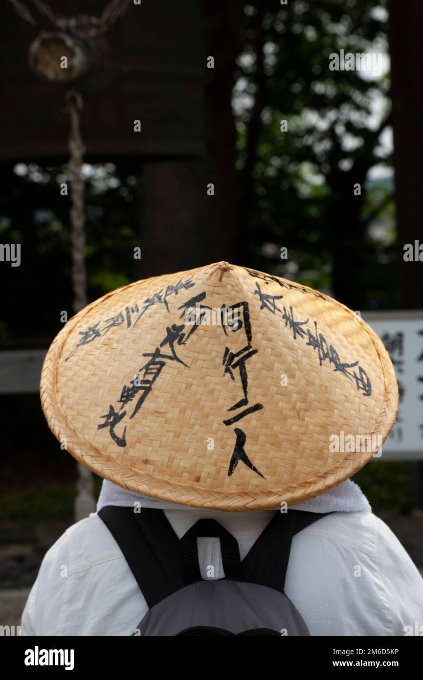 Ein Pilger in traditioneller Kleidung, aber mit einem modernen Rucksack besucht den Kanjizaiji-Tempel, Shikoku, Japan Stockfoto